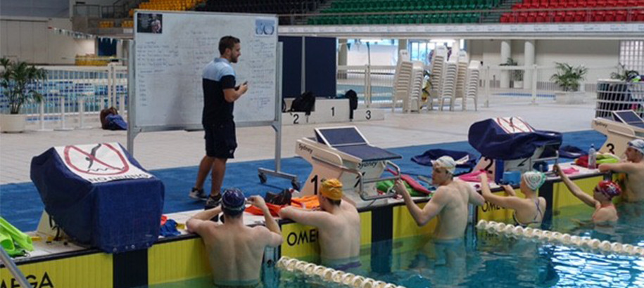 Coach standing at a white board leading a training session