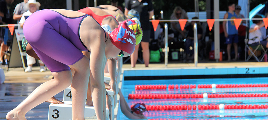 Club swimmers on the starting blocks at a meet